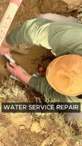 Photo of open trench and licensed plumber doing a water service line replacement by Green Country Plumbing